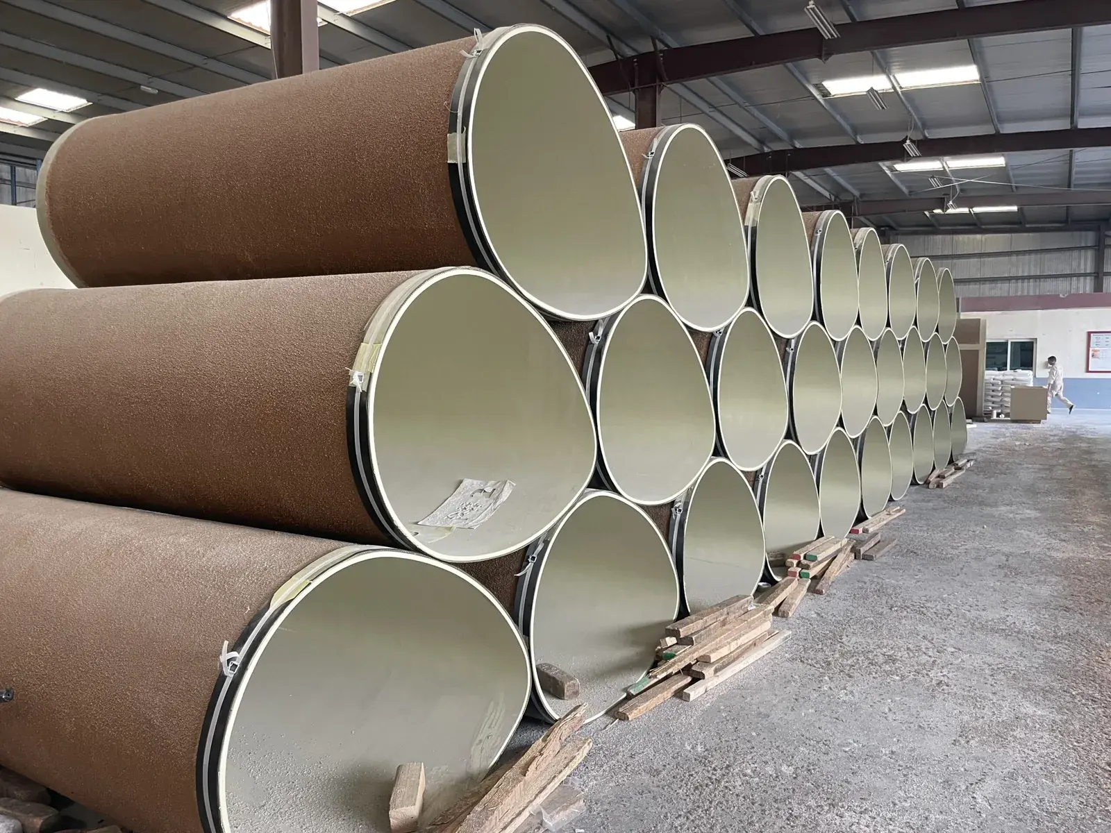 Coques PRV de grande dimension empilées dans une usine avant expédition